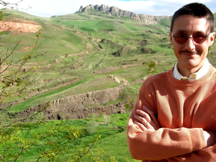 a man is standing outside by himself near some hills