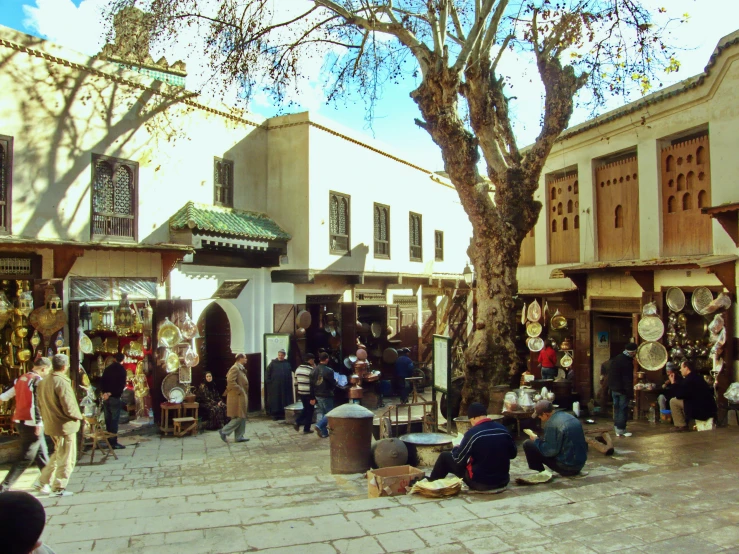 people sitting and walking around on benches with their belongings in front of shops