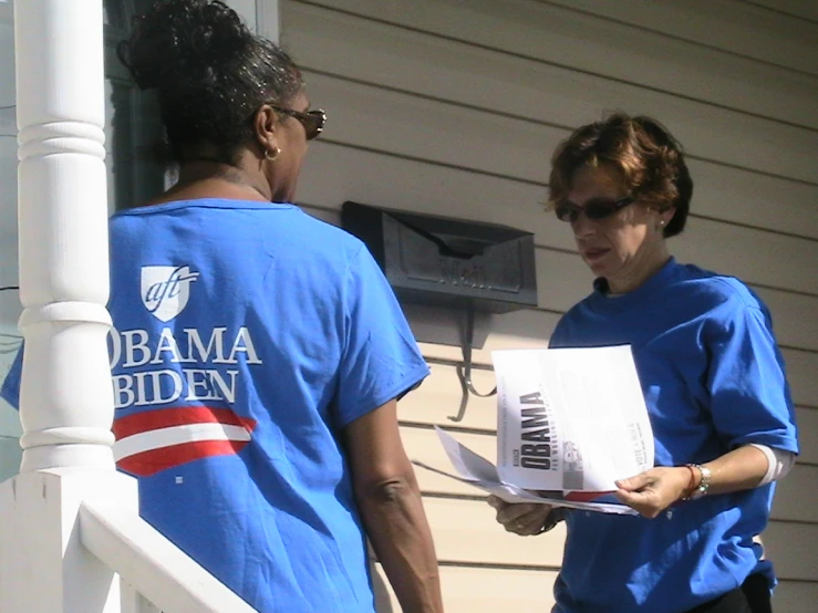 a lady is handing out soing from a woman in blue shirt