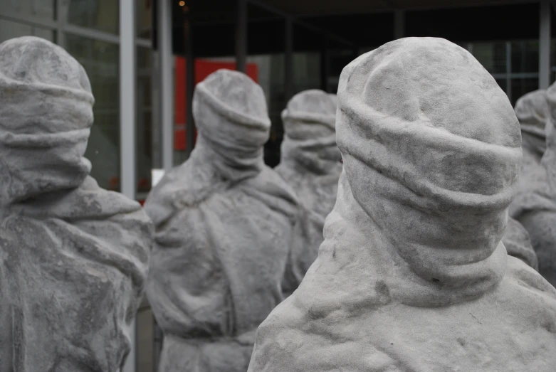 some statues of different sizes in front of a building