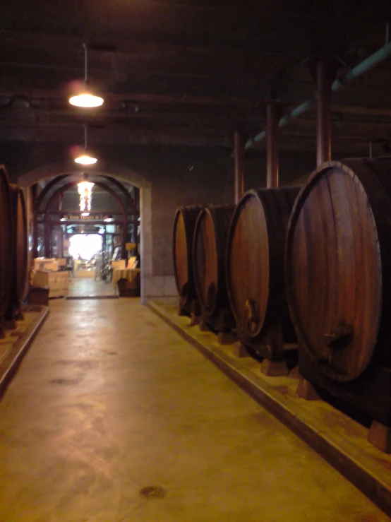 several wine barrels are lined up in a tunnel