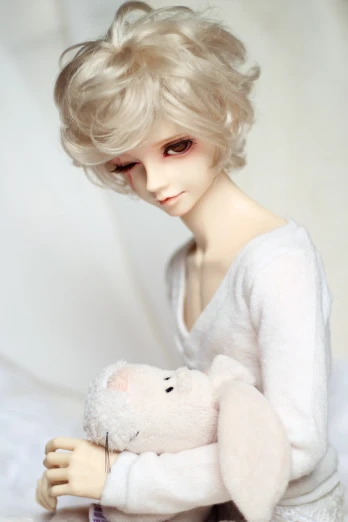 a doll dressed in a white sweater holding a stuffed rabbit