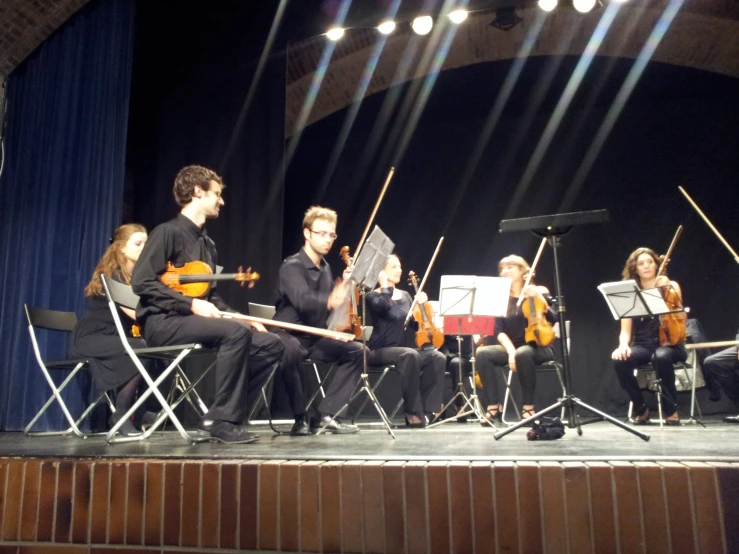 four musicians on stage performing an old - fashioned concert