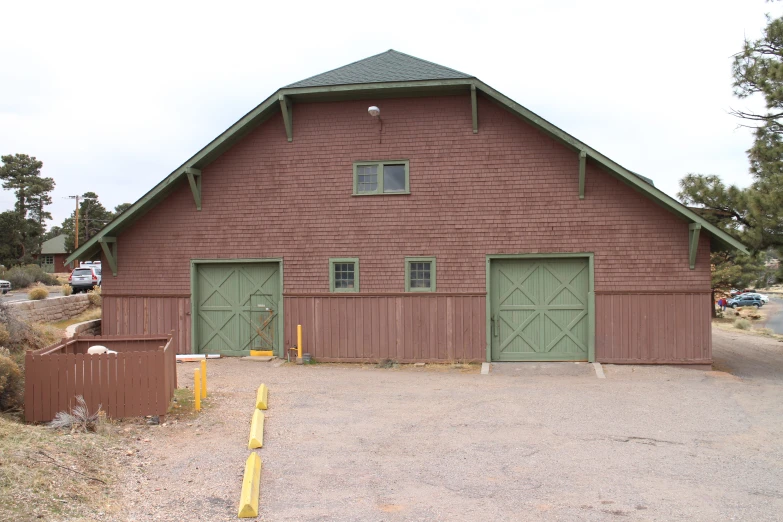 a brown barn has three doors that open