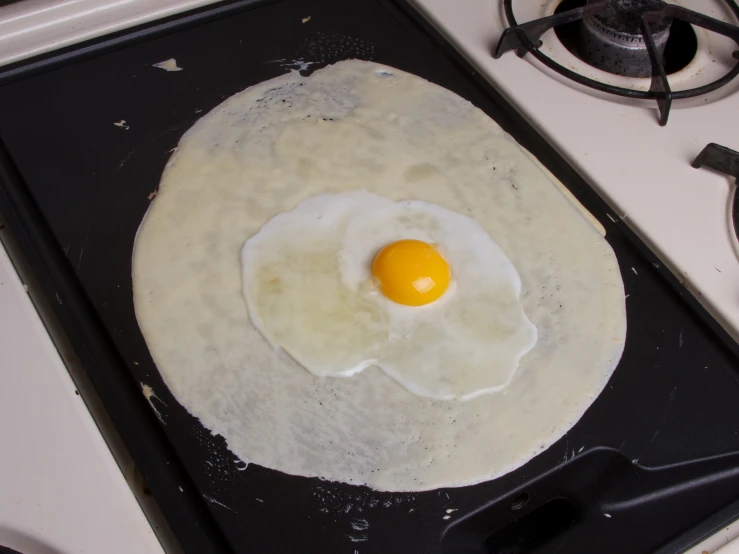 an egg is fried in the center of a pan