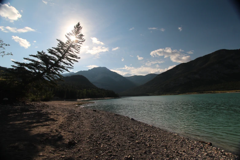 the sun shining down over a small lake