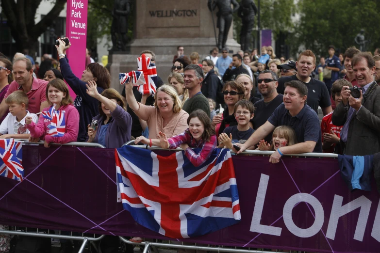 crowd of people gathered outside of an arena watching a parade