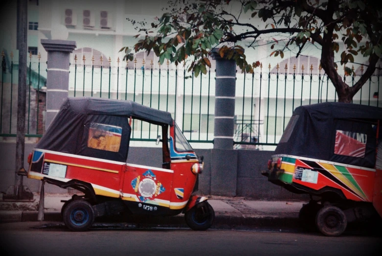 a red and green golf cart parked next to each other