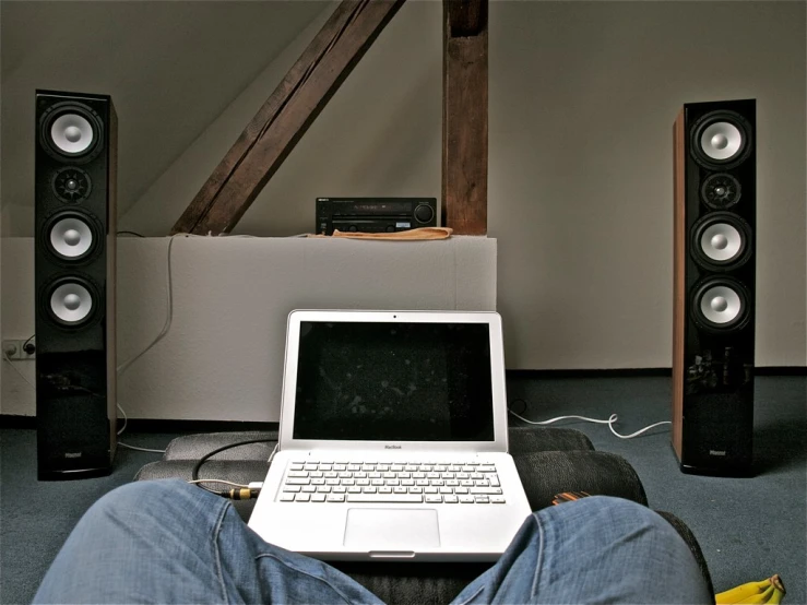 a person sits on the ground with his laptop on their lap