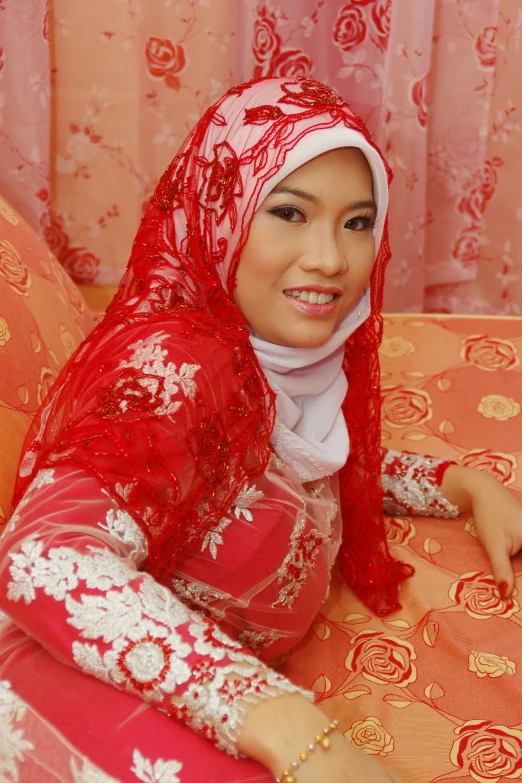 a young woman wearing a red scarf on top of a bed