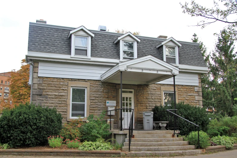 a house with grey and beige roof and landscaping