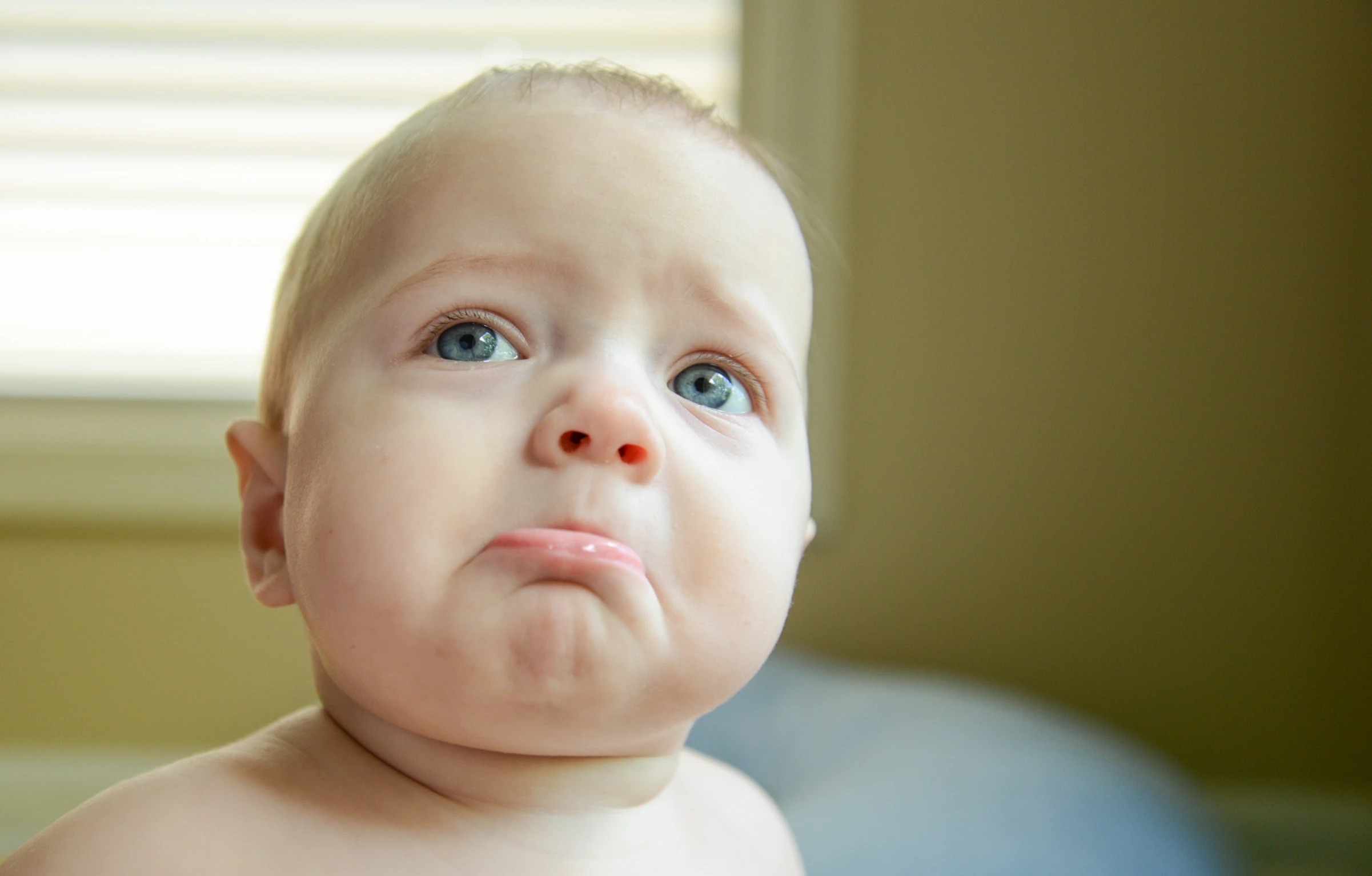 the baby is looking up while staring into the camera