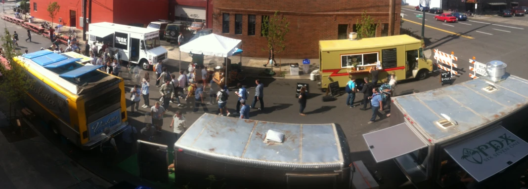 people are gathered outside on an outdoor market with food trucks