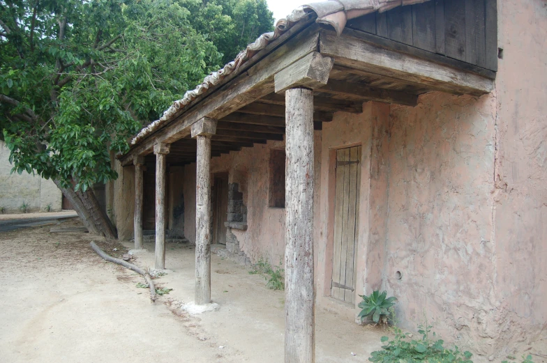 some people walk in front of old mud homes