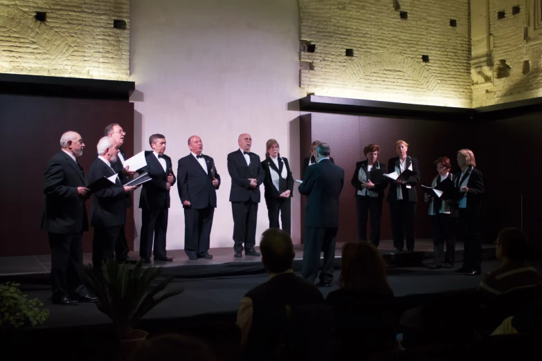 a group of men in tuxedos standing on stage