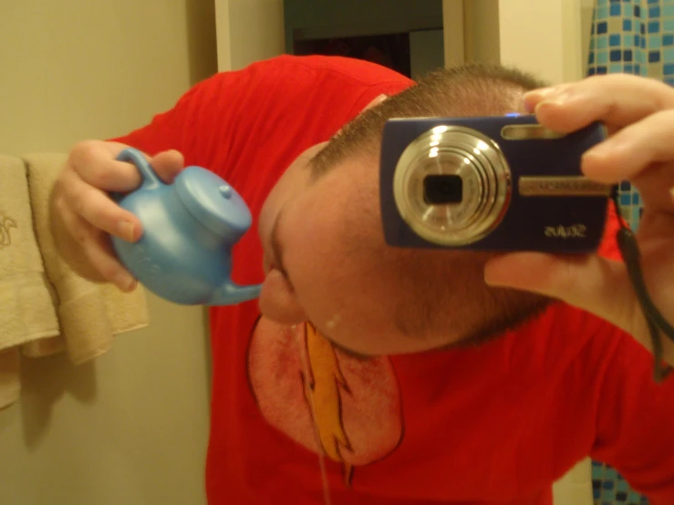 man with camera taking pic of himself in bathroom mirror