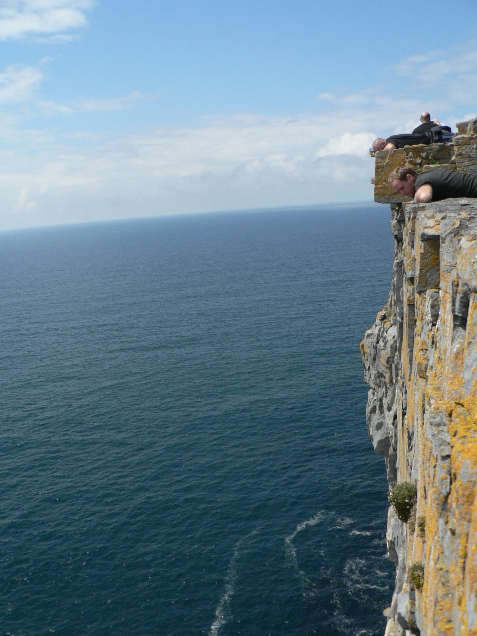 two men hang out on the cliff face