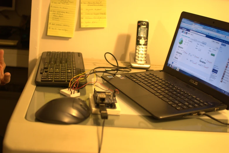 a computer on a table with a cord connected to it