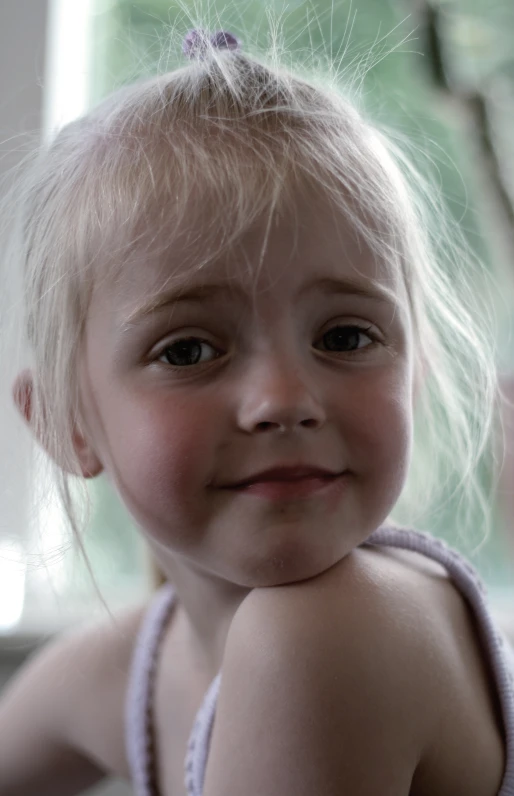 a small blond girl smiles into the camera