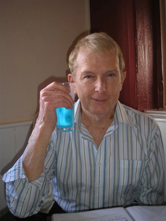 man holding a blue bottle and making a face