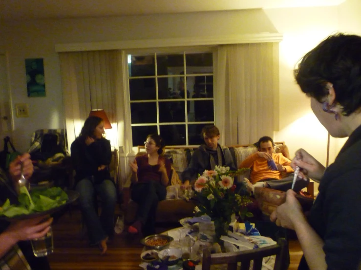 several people are gathered around a table talking