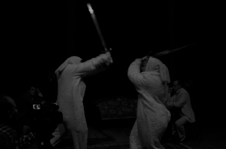 two people in bunny suits holding onto bats