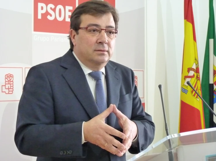 there is a man giving a speech in front of flags