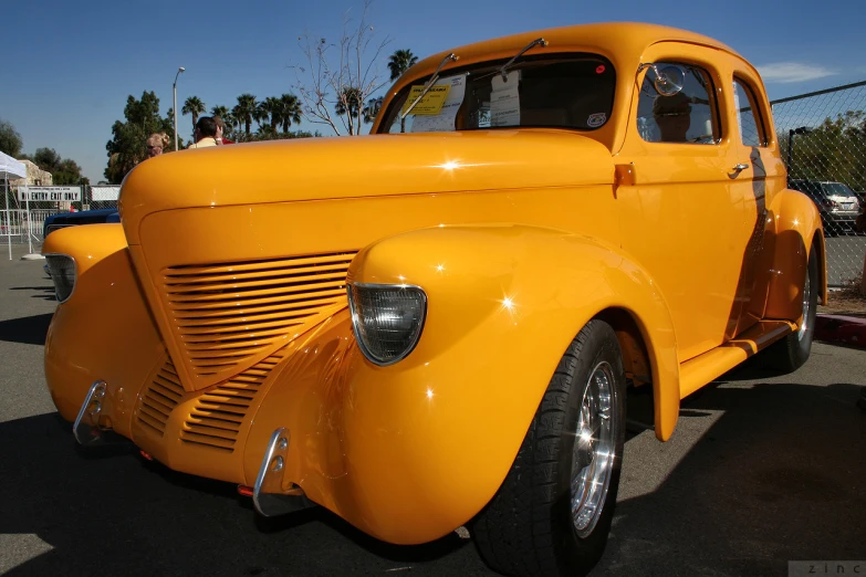 an antique yellow truck with shiny chrome front fenders