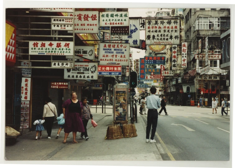 a group of people walking down a street near stores