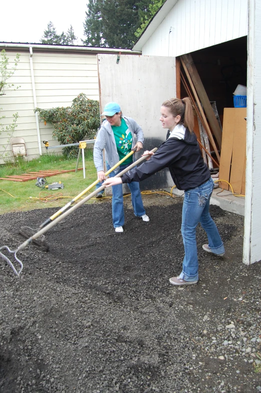 a couple of people working outside with a shovel