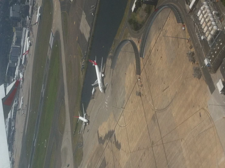 an aerial view of an airport with a large river behind it