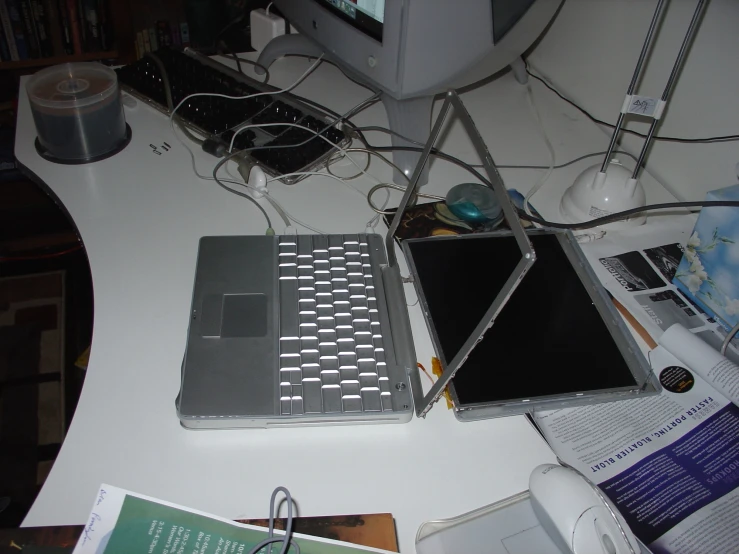 an all white computer with its laptop open on it's desk