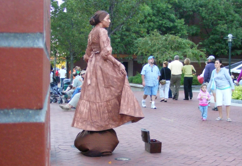 woman in evening dress standing on ground surrounded by people