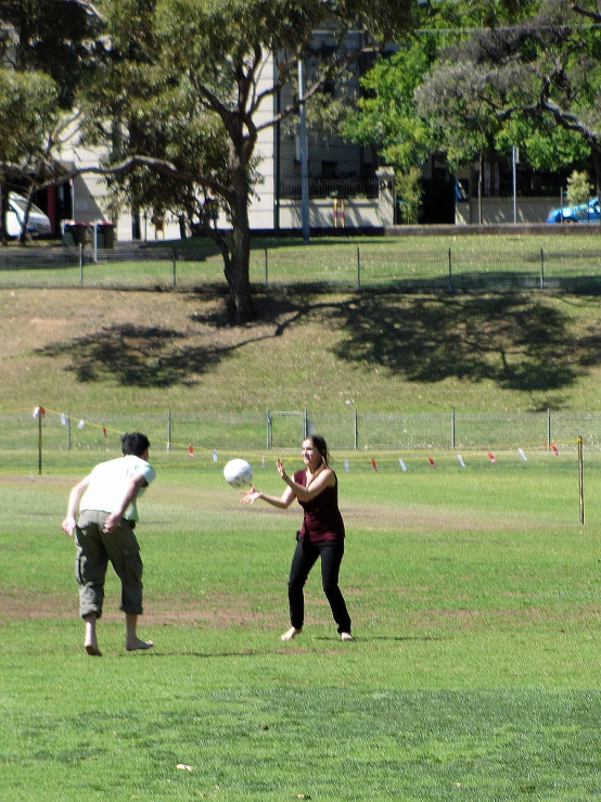 a man and woman standing on a field playing with a frisbee