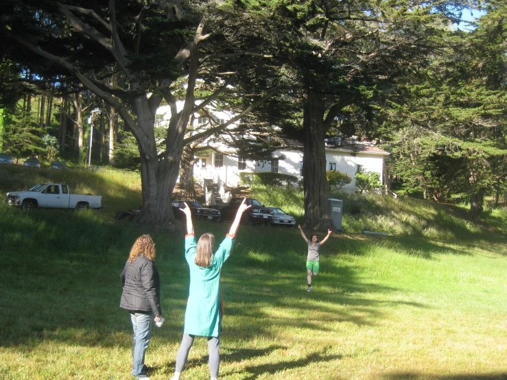 two girls in a field trying to get a flying disc