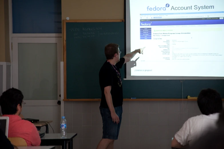 a man giving a lecture at a green board