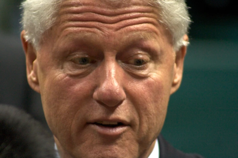 a man in a suit making face with two hands