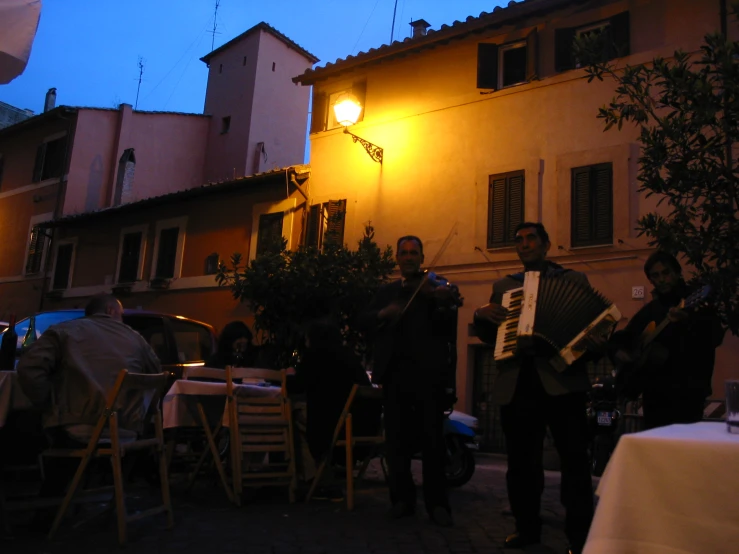 men playing an accordion at night under a street light