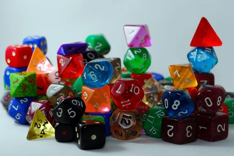 a pile of assorted shiny dice sitting on a table