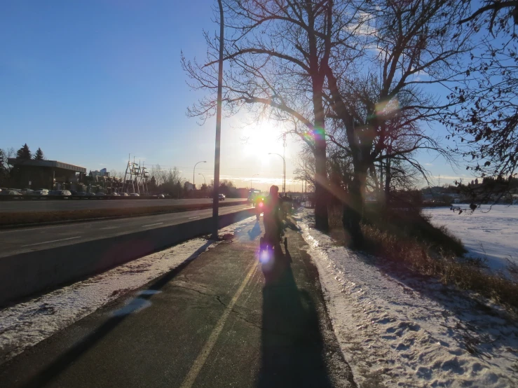 a person walking in the snow along side a street