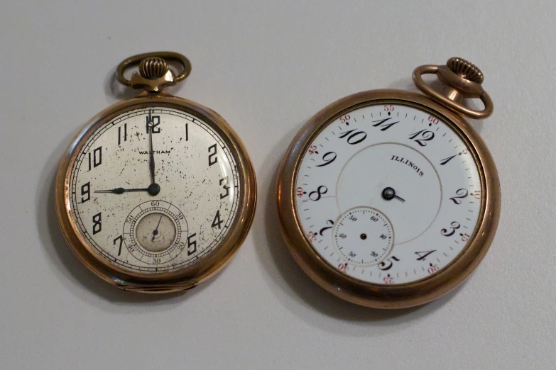 two old pocket watches on display on the wall