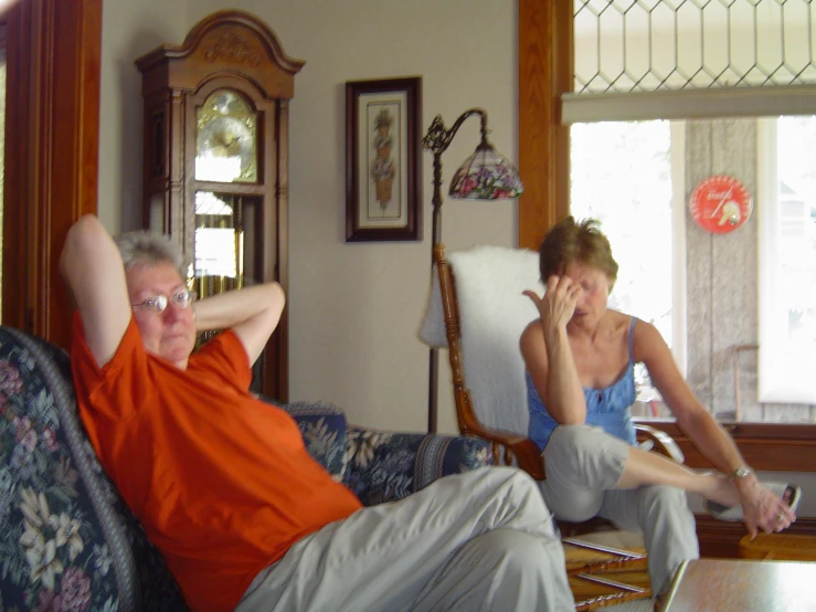 an older man and young woman relaxing on a couch