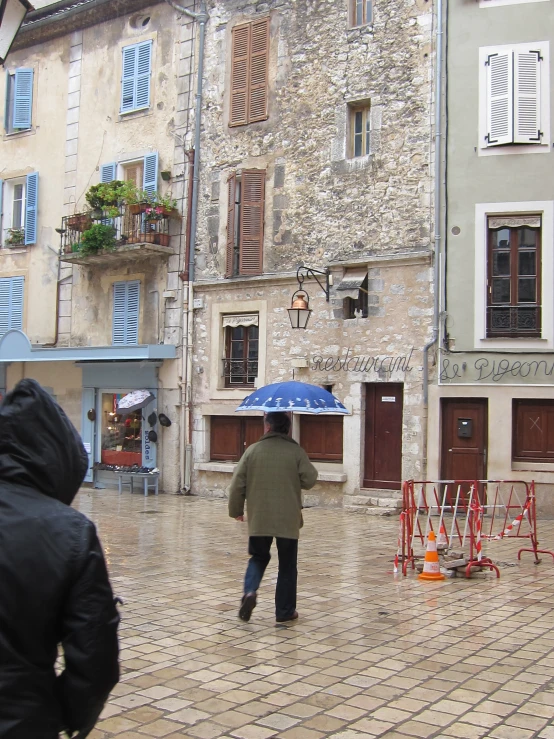 a person walking in the rain, with an umbrella