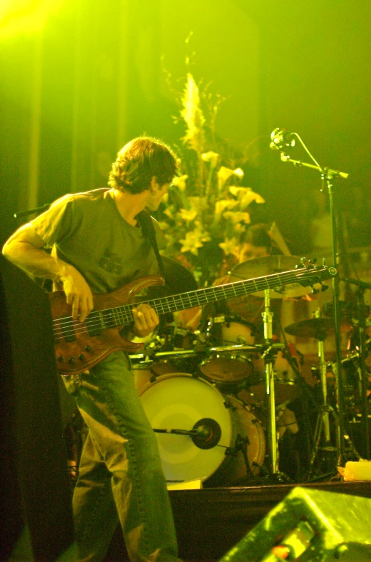 a man is playing a bass guitar in front of a band