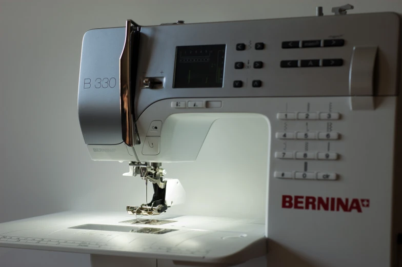 the sewing machine is setting on a white surface