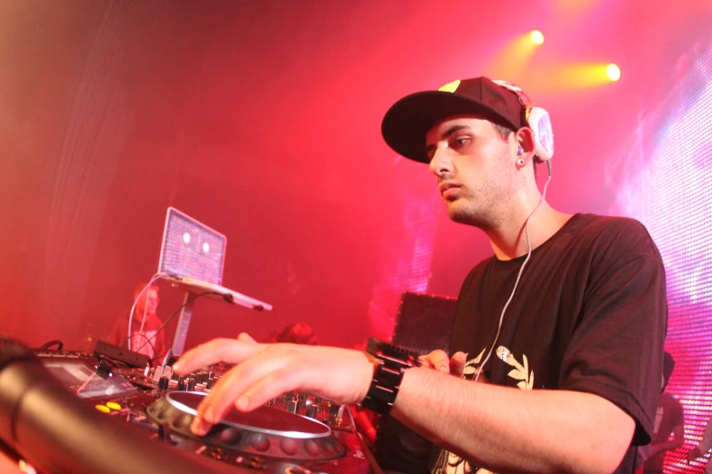 dj mixing on his turntable at nightclub