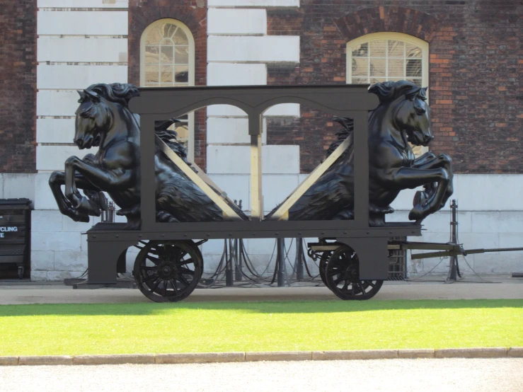 a horse - drawn carriage statue in front of an old building