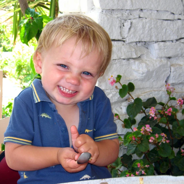 a young child sitting at a table with a plate of food