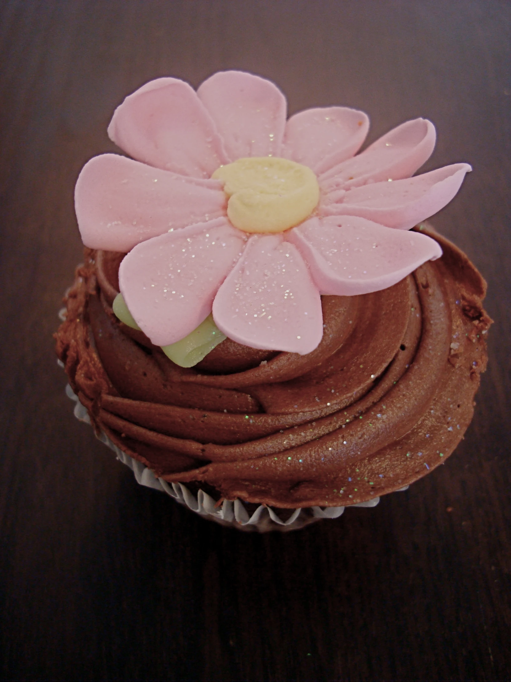 a close up of a cup cake with a flower on top