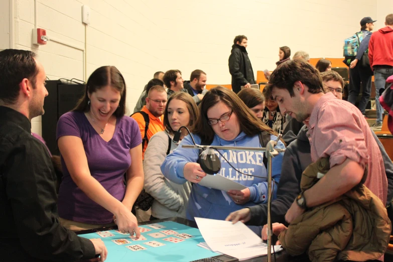 several people sitting and standing around a table